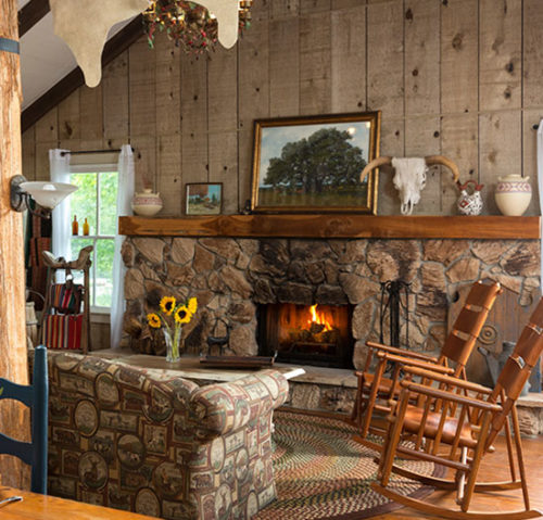 rocking chairs in front of stone fireplace