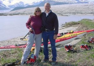 Pearson Pond, couple hugging on their honeymoon in Alaska with the mountains and a kayak in the background.