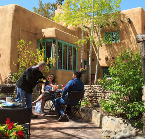 Innkeeper serving guests breakfast outside at this New Mexico Bed and Breakfast