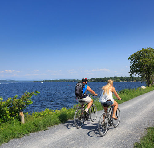 Couple biking along lake in Burlington Vermont
