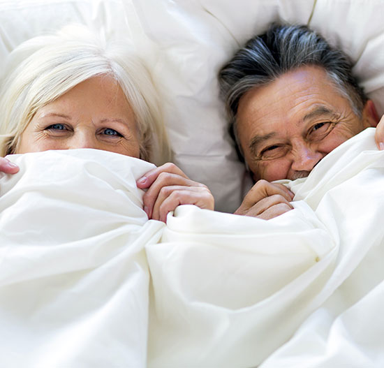 Couple in bed giggling with sheets pulled up, bnbfinder bed and breakfast directory