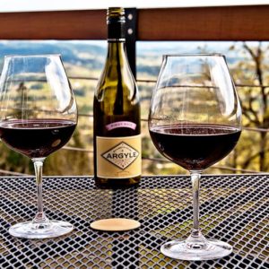 6 Wine Country Inns, glasses of wine on table looking out over Oregon wine country