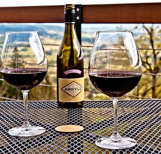 6 Wine Country Inns, glasses of wine on table looking out over Oregon wine country